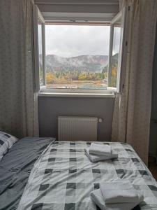 a bedroom with a bed and a large window at Way2Jaworzyna in Krynica Zdrój