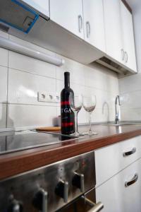 una botella de vino sentada en un mostrador con dos copas de vino en Stan na dan Paracin 035, en Paraćin
