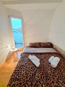 1 cama con 2 toallas blancas y ventana en Stan na dan Paracin 035, en Paraćin