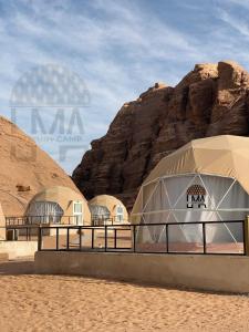 Un groupe de dômes dans le désert à côté d'une montagne dans l'établissement Lma Luxury Camp, à Wadi Rum