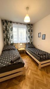 Habitación con 2 camas y ventana en Warszawa Krucza Pokoje, en Varsovia