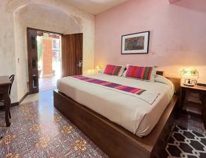 a bedroom with a large bed and a desk at Hotel Siglo XVII Art Gallery in Oaxaca City