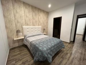 1 dormitorio con 1 cama y suelo de madera en Casa rural Huertas de Ubrique, en Ubrique