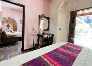a bedroom with a bed and a mirror and a bed at Hotel Siglo XVII Art Gallery in Oaxaca City