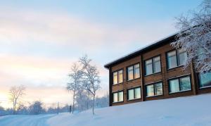 a house in the snow in the forest at Holiday Village Valle in Utsjoki