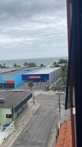 een uitzicht op een gebouw met een parkeerplaats en de oceaan bij Apto 3 dorm completo - 100m Praia - Meia Praia in Itapema