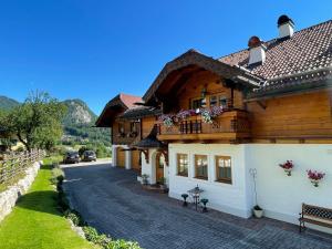 Casa de madera con balcón en una calle en Ferienwohnung Schossleitner - der Wohlfühl-Ansitz am Wolfgangsee mit Weitblick, en Sankt Gilgen