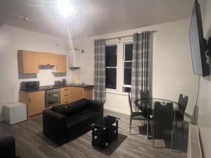 a living room with a table and a kitchen at Cosy central apartment near Stokes Croft in Bristol