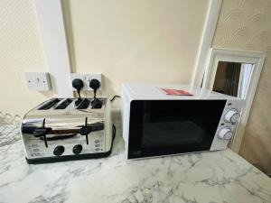 a microwave and a toaster oven sitting on a counter at Cosy flat in Little Paxton