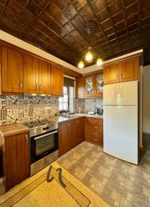 a kitchen with wooden cabinets and a white refrigerator at Vradeto Guesthouse in Vradéton