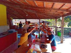 a group of people sitting around a table at Pousada e camping Canastra Mineira in São Roque de Minas
