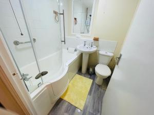 a bathroom with a toilet and a sink and a shower at Cosy flat in Little Paxton