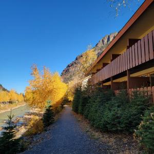 a dirt road next to a building with autumn trees at Hot Springs Inn in Ouray