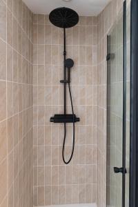 La salle de bains est pourvue d'une douche avec un pommeau de douche. dans l'établissement Cabana & La Grange Maison Mâcon Nord, à Saint-Martin-Belle-Roche