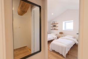 - un miroir dans une chambre avec 2 lits dans l'établissement Cabana & La Grange Maison Mâcon Nord, à Saint-Martin-Belle-Roche