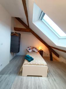 ein Schlafzimmer mit einem Bett im Dachgeschoss in der Unterkunft La Grange in Toury
