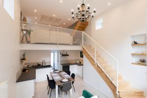 une cuisine et une salle à manger avec un escalier, une table et des chaises dans l'établissement Cabana & La Grange Maison Mâcon Nord, à Saint-Martin-Belle-Roche
