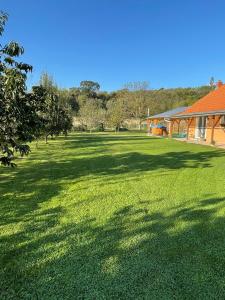 a large green field with a building and trees at Mónika Apartman Zalaszabar in Zalaszabar