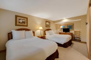 a hotel room with two beds and a desk at 604 Disciples Village Condo in Boyne Falls