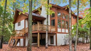 a cabin in the woods with a deck at 604 Disciples Village Condo in Boyne Falls