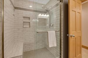 a bathroom with a shower with a glass door at 604 Disciples Village Condo in Boyne Falls +33 photos