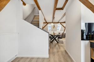 a hallway with white walls and a dining room with a table at EasyApartments stilvoll zentral Balkon Hauptbahnhof NETFLIX 130m2 in Hof