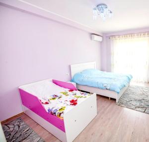 a bedroom with two beds and a drawer with flowers on it at Happy stories' apartment in city centre in Shkodër