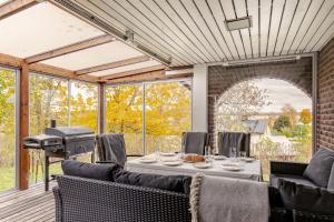 un porche cubierto con mesa y parrilla en Large family home by the water, en Östhammar