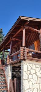 a building with a wooden roof and a stone wall at Chalet Aroania in Kalavrita