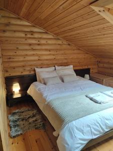 a bed in a room with a wooden ceiling at Chalet Aroania in Kalavrita