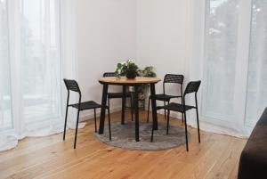 a table with four chairs and a plant on it at Bella's Appartment - Beautiful, modern and next to metro in Vienna