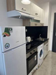 a kitchen with a white refrigerator and a washing machine at City Center studio Amelia in Plovdiv