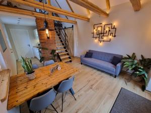 un soggiorno con tavolo in legno e divano blu di Ferienhaus-DP8 a Staupitz