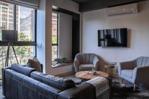 a living room with a couch and chairs and a tv at 208, The Duke - Luxury apartment with city views in Cape Town