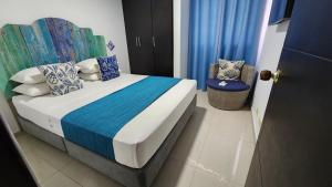 a bedroom with a bed and a chair in it at White Coral ApartaSuites in San Andrés