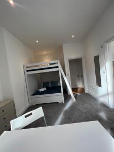 a room with a bunk bed and two white chairs at Excellent West Hampstead Studio in London