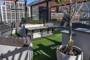 a patio with a table and a tree on a building at 208, The Duke - Luxury apartment with city views in Cape Town