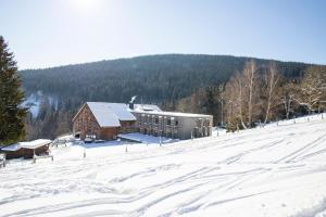 un edificio en la cima de una montaña cubierta de nieve en Amenity Hotel & Resort Špindlerův Mlýn en Špindlerův Mlýn