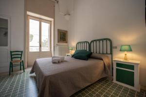 1 dormitorio con 1 cama, 1 silla y 1 ventana en Villa Clori, en Salice Salentino