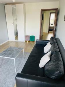 a black leather couch in a living room with a table at Apartament Sunny Home in Nowy Targ