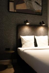 una camera d'albergo con un letto con cuscini bianchi di Centrum Nice a Nizza