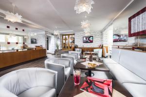 un restaurante con mesas y sillas blancas y un bar en Hotel Central, en Nyíregyháza