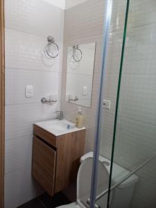 y baño con aseo, lavabo y ducha. en Cabañas GARUTO, en Los Santos