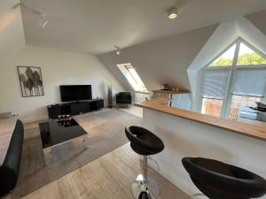 sala de estar con 2 taburetes y TV en attraktives Appartement im Stadtzentrum Plauen Balkon Lift en Plauen
