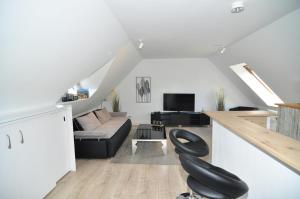 - Silla negra en la sala de estar con sofá en attraktives Appartement im Stadtzentrum Plauen Balkon Lift en Plauen