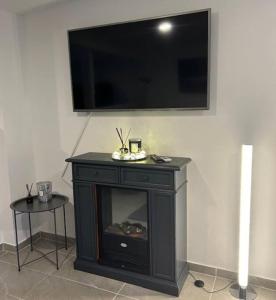 a black fireplace with a flat screen tv on a wall at ruhig wohnen im kleinen Bungalow im Süden von Berlin in Teltow