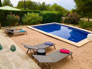 einen Pool mit 2 Liegestühlen und einem Sonnenschirm in der Unterkunft Schöne meernahe Villa mit Pool+Grill, Nähe Artà in Colònia de Sant Pere