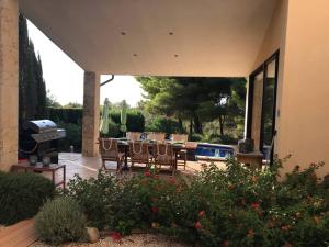 eine Terrasse mit einem Tisch, Stühlen und einem Grill in der Unterkunft Schöne meernahe Villa mit Pool+Grill, Nähe Artà in Colònia de Sant Pere