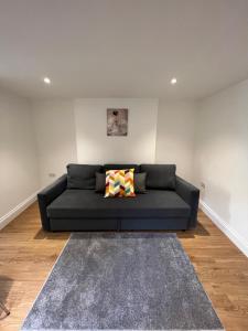 a living room with a black couch and a rug at Amazing One Bed Flat West Hampstead in London