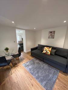 a living room with a couch and a glass table at Amazing One Bed Flat West Hampstead in London